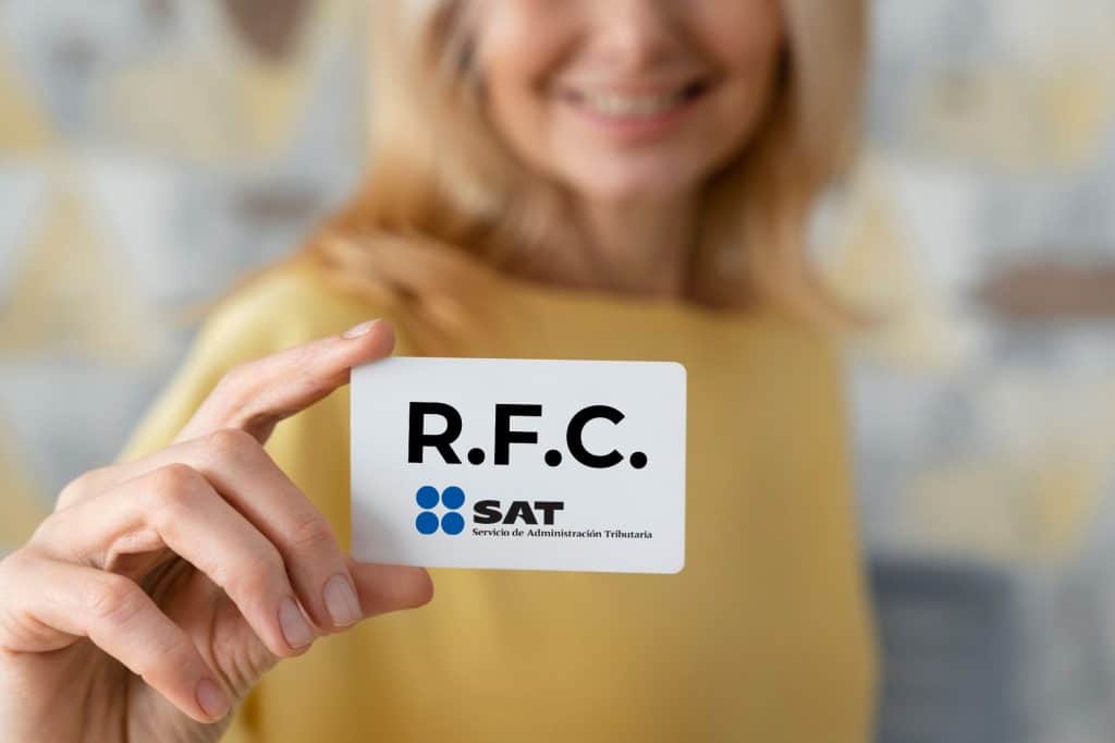 Mujer sosteniendo en la mano su carnet con el numero de RFC (Registro Federal de Contribuyentes) del SAT.